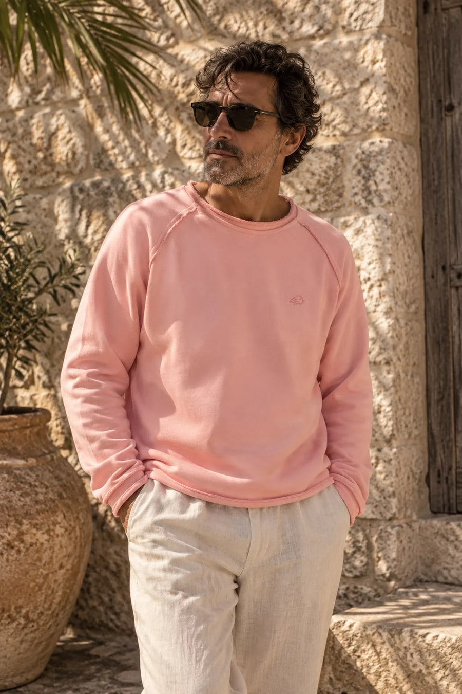 Gavilan – Sweatshirt in Altrosa vor einer Natursteinmauer